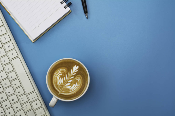 Une tasse de café avec clavier et espace de copie sur fond bleu
. - Photo, image