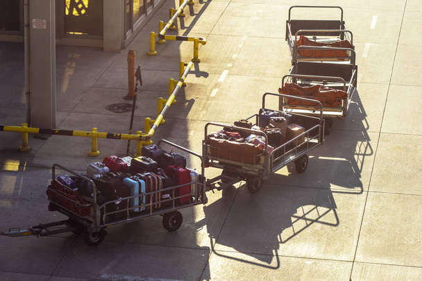 Κωνσταντινούπολη, Τουρκία - Νοέμβριος 2019. Ειδικό όχημα για τη μεταφορά αποσκευών στο αεροδρόμιο. Ρυμουλκούμενα φορτωμένα με τσάντες και βαλίτσες. - Φωτογραφία, εικόνα