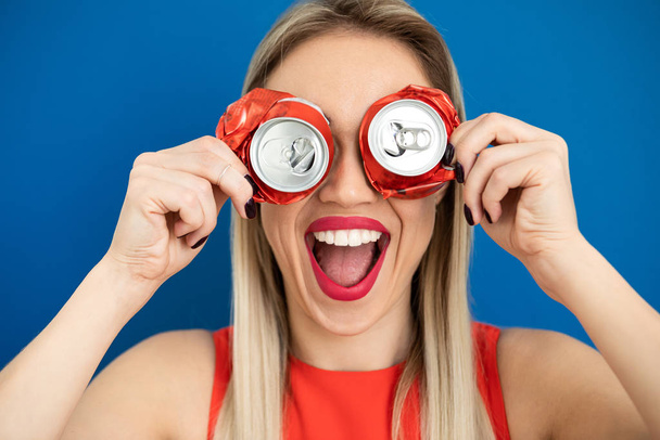 woman holding as glasses cans. Blue background. Red lips, big smile - Foto, imagen