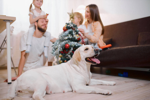 children and parents decorating christmas tree at home - Photo, Image
