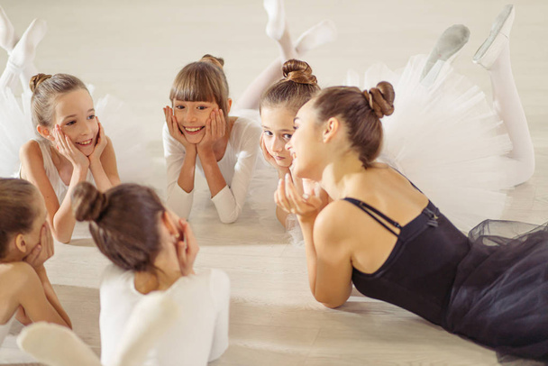 young ballerina lying on floor with kids - Valokuva, kuva