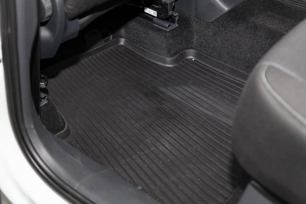 Saubere Fußmatten aus schwarzem Gummi unter dem Beifahrersitz - Foto, Bild
