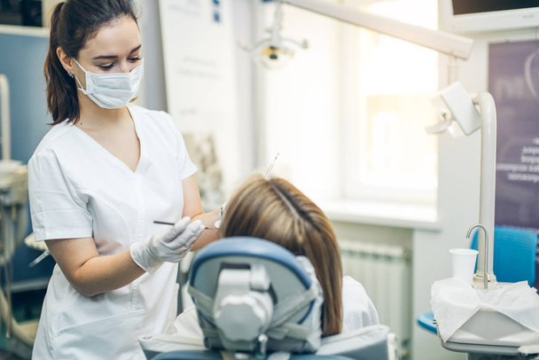 careful professional dentist woman treating teeth - Fotografie, Obrázek