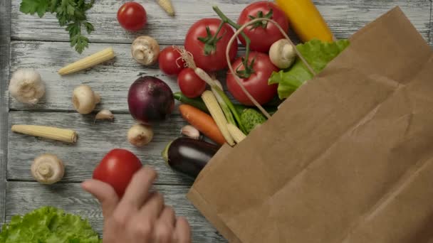Mans mano girando tomate cerca de comestibles y verduras saco
 - Imágenes, Vídeo