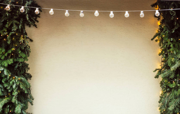Stěna s věnec lamp, vánoční borovice a světla a dekorace, zimní slavnostní pozadí - Fotografie, Obrázek