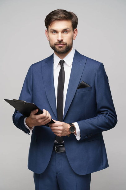 Portrait of a handsome young business man holding folder - Fotoğraf, Görsel
