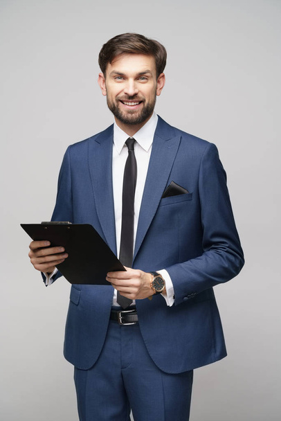 Portrait of a handsome young business man holding folder - Foto, Imagen