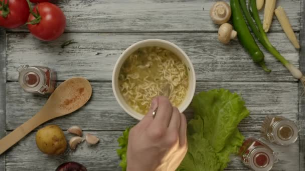 Ernteköchin mixt köstliche billige Nudelsuppe mit Gabel - Filmmaterial, Video