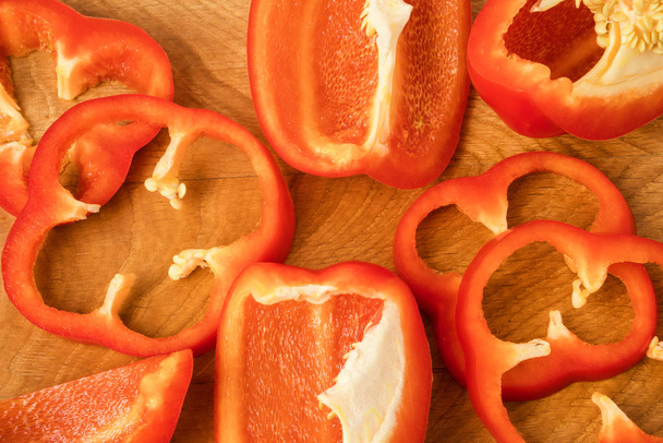 red bell pepper cut into pieces on a wooden board - Foto, Bild