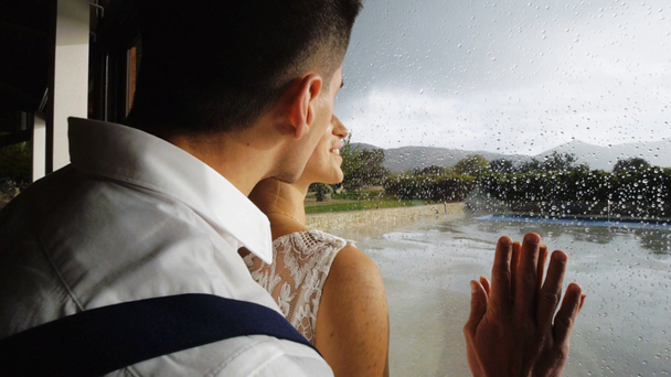 Υπέροχο ζευγάρι κοντά στο παράθυρο με σταγόνες βροχής. - Πλάνα, βίντεο