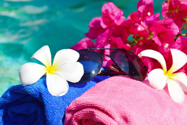 Flowers, towel and water. Recreation at the pool.  - Fotó, kép