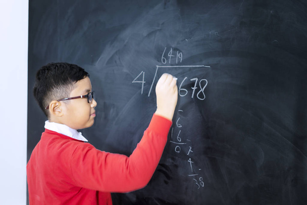 Side view of an adorable boy solving calculations - Foto, Imagem