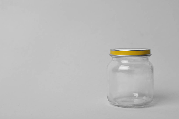 Closed empty glass jar on light background, space for text - Zdjęcie, obraz