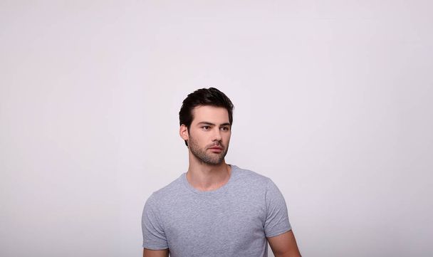 A young handsome guy with a beard on a gray background. - Foto, Imagen