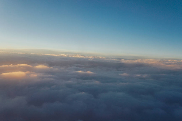 Sky with clouds at sunset from inside the plane landscape - Photo, Image