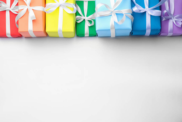 Bright gift boxes on white background, top view. Rainbow colors - Φωτογραφία, εικόνα