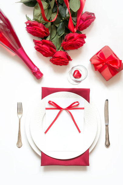 Romantic table setting with bouquet of red roses and gift. View from above. Valentine day. - Fotografie, Obrázek
