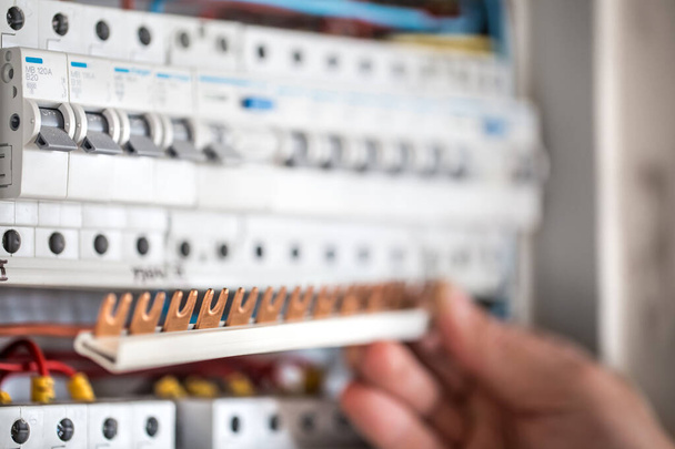 Mann, ein Elektrotechniker arbeitet in einem Schaltschrank mit Sicherung - Foto, Bild