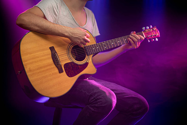 El músico toca una guitarra acústica. Hermoso fondo con
 - Foto, Imagen