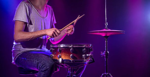 The drummer plays the drums. Beautiful blue and red background,  - Fotó, kép