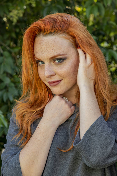Beautiful woman with red hair and freckles outdoors - Foto, afbeelding
