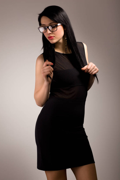 Young brunette woman in black clothing and glasses - Фото, зображення