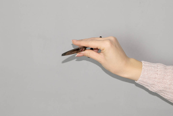 Жінка тримає перукарські ножиці на білому тлі
 - Фото, зображення
