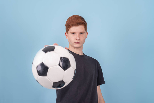 Strzał rudego nastolatka trzymającego piłkę w ręku  - Zdjęcie, obraz