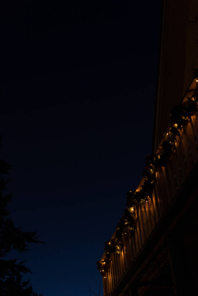 Guirnaldas navideñas con velas en balcón de madera blanca
. - Foto, Imagen