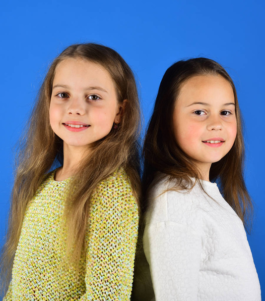 Sisters and friends with smiling faces on blue background - Foto, imagen