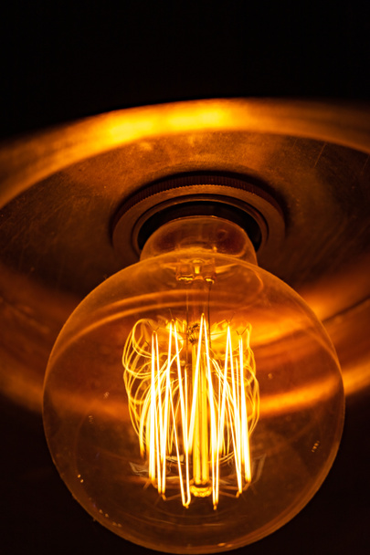 La vieja lámpara incandescente brilla amarillo
. - Foto, imagen