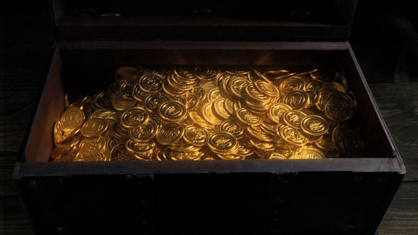 As moedas de ouro brilhantes mágicas enchem o baú de madeira
 - Filmagem, Vídeo