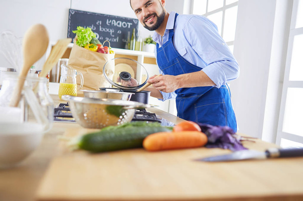 Man preparing delicious and healthy food in the home kitchen - Foto, afbeelding