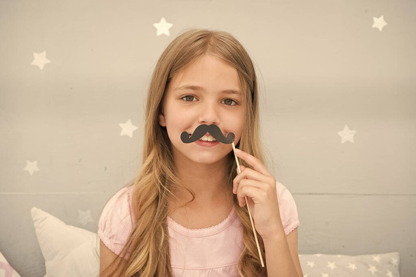 Having fun with fake mustache. Happiness and humor concept. Kid long hair happy smile face. Girl carefree child having fun with mustache. Play with mustache photo booth props. Hair care and beauty - Фото, зображення
