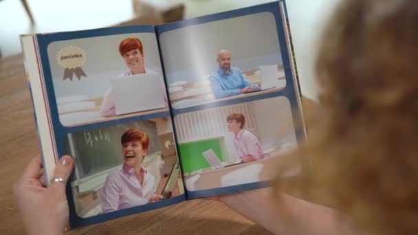 vrouw die fotoboek bekijkt met foto 's van school - Video