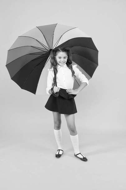 Stay dry. Fancy schoolgirl. Girl with umbrella. Rainy day. Happy childhood. Rainbow style. Kid happy with umbrella. Fall weather forecast. Fashion accessory. Rainy september. Accessory for rainy day - 写真・画像