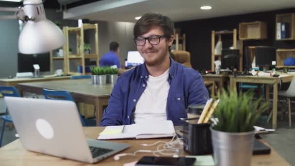 Junger Mann schaut lustiges Video im Büro - Filmmaterial, Video