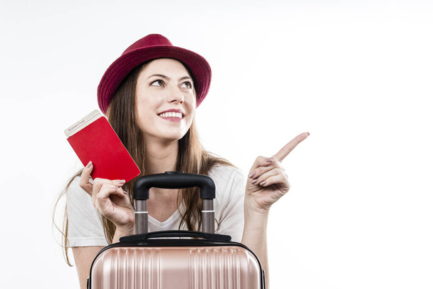 Porträt eines Touristen mit Pass und Ticket, der mit dem Finger auf weißem Hintergrund zeigt. Flugreise-Konzept. - Foto, Bild