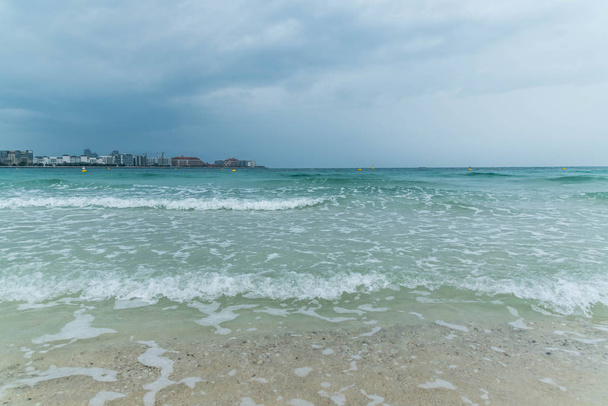 Dramaattinen pilvinen taivas ja ukkonen, Sea Waves Jumeirah Beachilla Dubaissa, Arabiemiirikunnissa
. - Valokuva, kuva