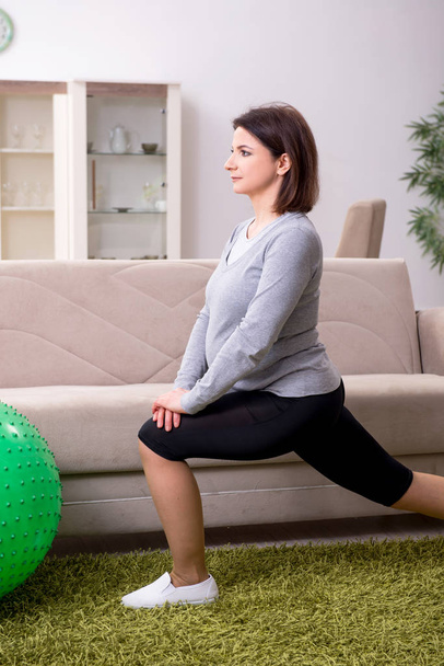 Mujer embarazada envejecida haciendo ejercicios en casa
 - Foto, Imagen