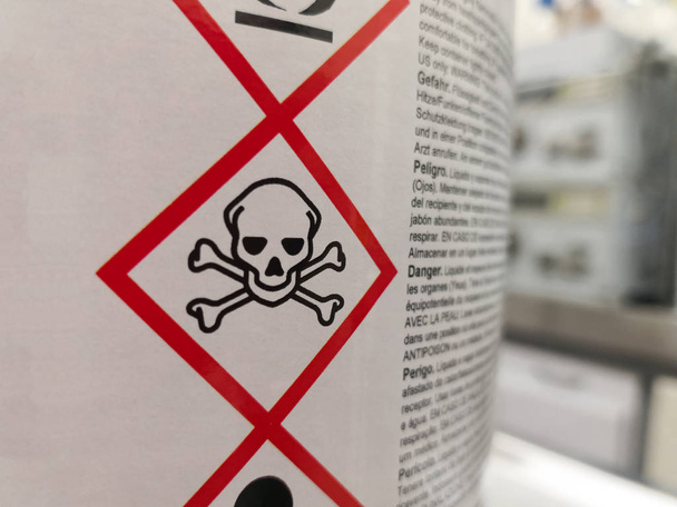 Bilimsel bir laboratuvarda tehlikeli bir kimyasalın etiketi. Zehirlenme ve ölümle ilgili uyarı simgeleri. - Fotoğraf, Görsel