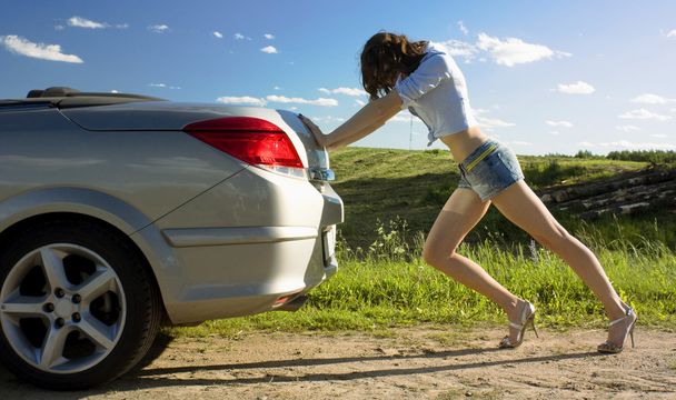 La donna sta spingendo un'auto rotta
 - Foto, immagini