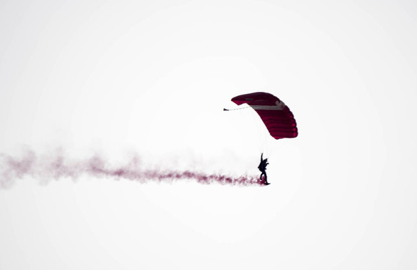 Силуэт парашютный трюк несосредоточен и размыт во время скольжения в
 - Фото, изображение