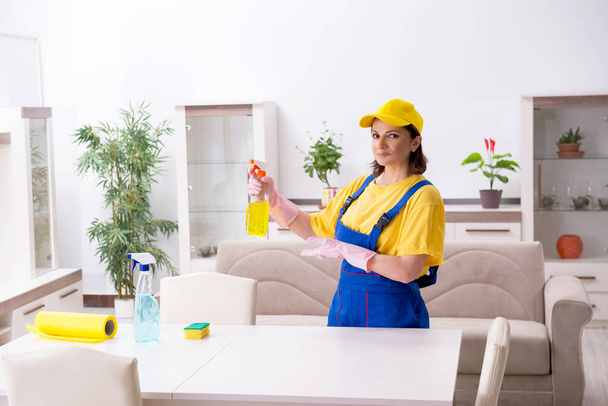 Oude vrouwelijke aannemer doet huishoudelijk werk - Foto, afbeelding