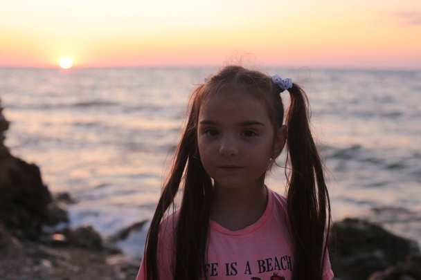 κορίτσι με μακριά μαλλιά στο ηλιοβασίλεμα από τη θάλασσα η ομορφιά της φύσης αυγή - Φωτογραφία, εικόνα