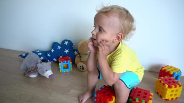menino sonhador sentado em blocos coloridos em casa. Movimento de Gimbal
 - Filmagem, Vídeo