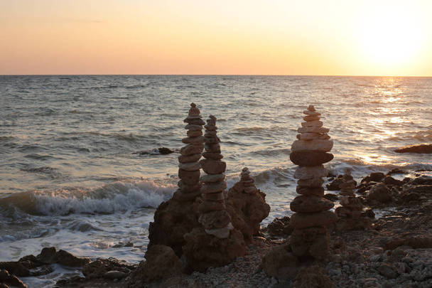 equilibrio de piedras al atardecer junto al mar la belleza de la naturaleza del amanecer
 - Foto, Imagen
