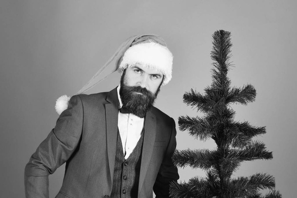 Businessman with serious face near bald Christmas tree. - Foto, Bild