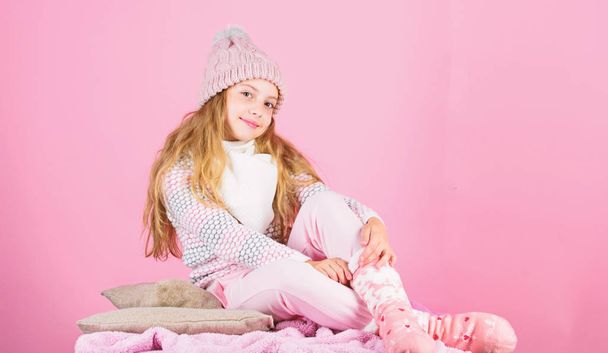 Warm accessories that will keep you cozy this winter. Kid girl wear knitted warm hat relaxing pink background. Winter fashion warm clothes concept. Child long hair warm woolen hat enjoy warm - Photo, image