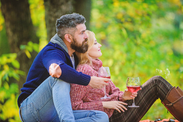 Family picnic. Happy couple. happy woman and bearded man drink wine. love date and romance. Spring mood. Red wine in fall weather. couple in love relax in autumn forest. I know everything about wine - Foto, afbeelding
